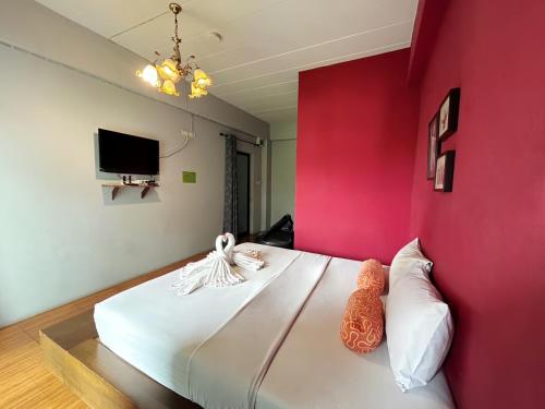 a bedroom with a large bed with a red wall at Hide Bangkok Hostel in Bangkok