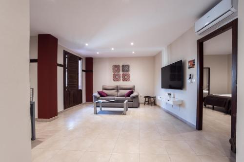 sala de estar con sofá y TV en Apartamentos Reyes Católicos, en Granada
