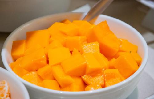 a white bowl filled with orange cut up fruit at Aku Hotels in Lima