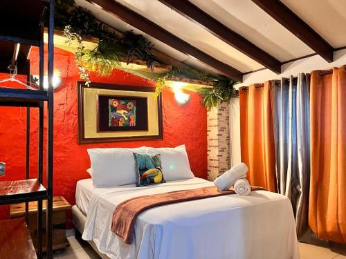 um quarto com uma cama com uma parede laranja em Panama House Bed & Breakfast na Cidade do Panamá