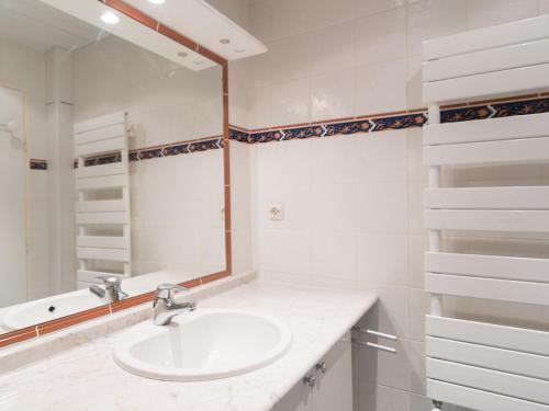 une salle de bain blanche avec un lavabo et un miroir dans l'établissement 3 pièces au pied des pistes, exposé sud, 65m², 3 chambres - FR-1-449-6, à Tignes