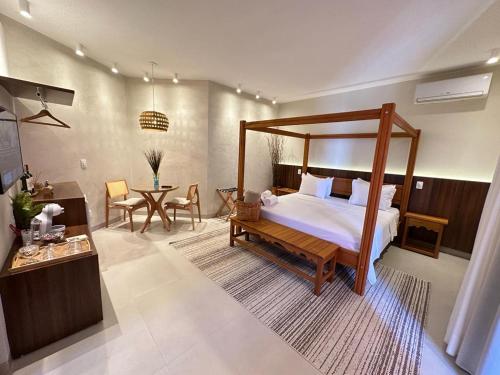 1 dormitorio con cama con dosel, mesa y sillas en Pousada Villa Mariana, en Pirenópolis