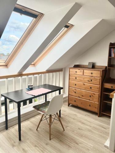 a attic room with a desk and a dresser at Mandala Koszalin in Koszalin