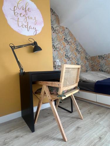 a desk with a lamp and a chair next to a bed at Mandala Koszalin in Koszalin