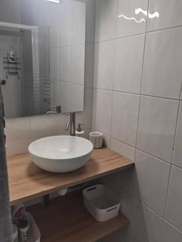 La salle de bains est pourvue d'un lavabo blanc et d'un miroir. dans l'établissement Agréable T1 bis en bord de Loire, à Blois