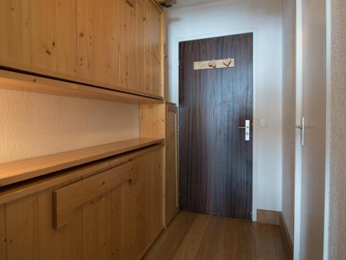 - un couloir avec une porte dans une chambre avec des armoires en bois dans l'établissement Studio Sud/Ouest à Tignes - Proche pistes, balcon, Wifi - FR-1-449-134, à Tignes