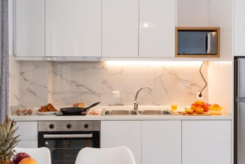 a kitchen with a sink and a microwave at PROPAN CITY SUITES in Volos