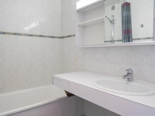 une salle de bain blanche avec un lavabo et un miroir dans l'établissement 2 pièces Sud à 500m des pistes, Wifi, TV - FR-1-449-157, à Tignes