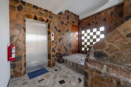 a bathroom with a walk in shower in a stone wall at 21 hotel in Pattaya Central