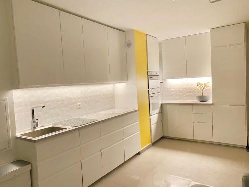 a kitchen with white cabinets and a sink at Nice Apartment Disneyland Paris in Chessy