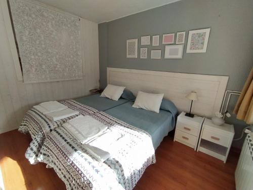 Schlafzimmer mit einem Bett mit blauer Decke in der Unterkunft Tu Casita de Vacaciones in Aramón Cerler