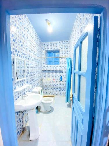a blue bathroom with a toilet and a sink at Casa Marisco in Chefchaouene