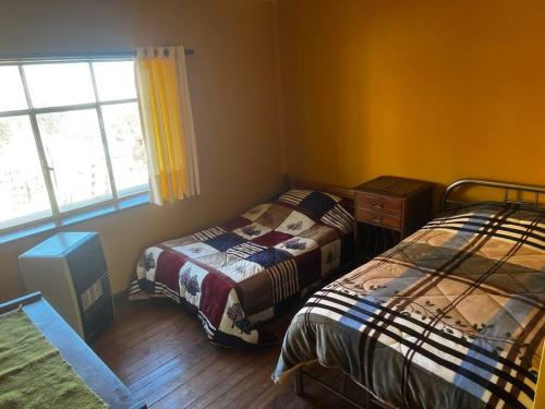 1 dormitorio con 2 camas y ventana en Don Julio’s House en La Paz