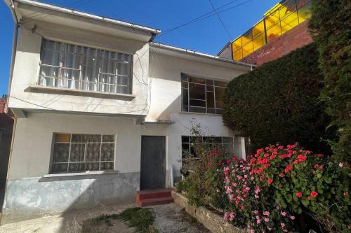 una casa blanca con flores delante en Don Julio’s House en La Paz