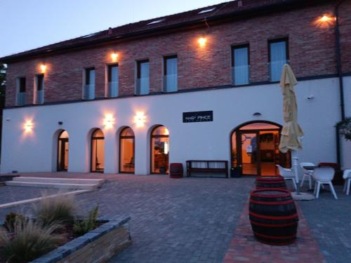 a building with a patio with a umbrella and chairs at Nagypince Borhotel Wine and Spa in Böhönye