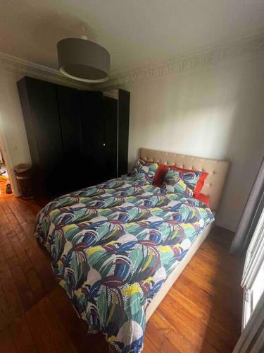 - un lit avec une couette colorée dans une chambre dans l'établissement Stade de France ! Grand 2 pièces, à Saint-Denis