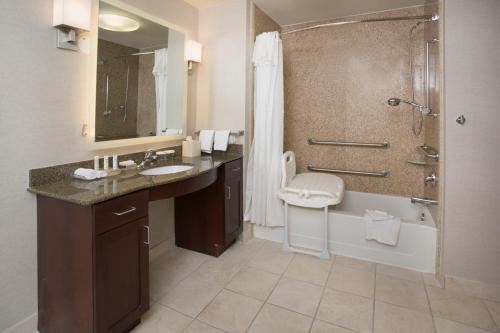 y baño con bañera, lavamanos y ducha. en Homewood Suites by Hilton Phoenix-Avondale, en Avondale