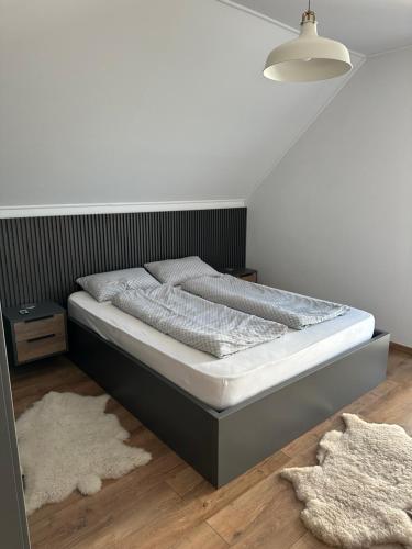 d'une chambre avec une tête de lit noire et du parquet. dans l'établissement Bokorlak 4, à Odorheiu Secuiesc