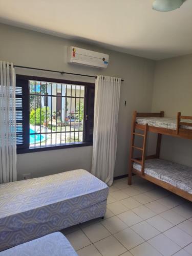 a bedroom with two beds and a window at Hostel Atairú in Natal