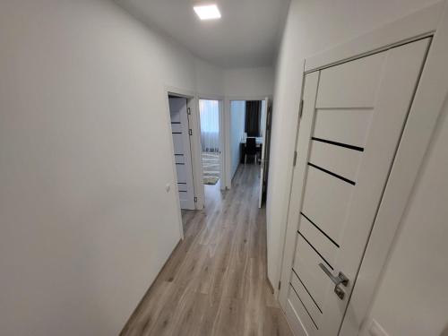 a hallway with white walls and a white door at Apartment Buiucani in Chişinău