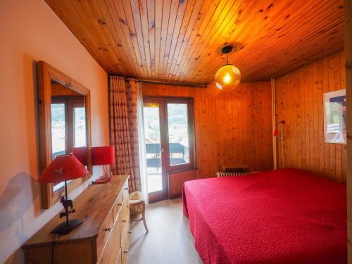 ラ・クリュサにあるAppartement La Clusaz, 2 pièces, 4 personnes - FR-1-459-114の赤いベッドと木製の天井が備わるベッドルーム1室が備わります。
