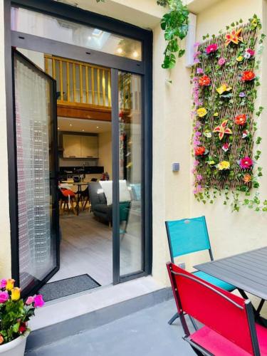 - une terrasse avec une table, des chaises et des fleurs dans l'établissement Cœur de Sète Le Patio 2, à Sète