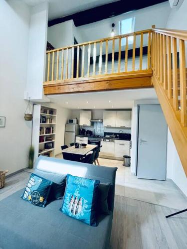 - un salon avec un canapé bleu et un escalier dans l'établissement Cœur de Sète Le Patio 2, à Sète