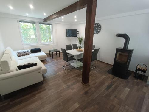 Riverside Guesthouse في Ig: غرفة معيشة مع أريكة بيضاء وموقد خشب