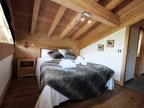 una camera da letto con un grande letto in una camera in legno di Chalet cosy accès pistes, sauna, cheminée, Wifi, parking - FR-1-344-411 a Saint-Martin-de-Belleville