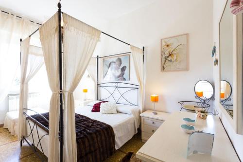 a bedroom with a canopy bed and a table at Casa Laura Follonica in Follonica