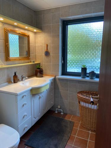 baño con lavabo y ventana en Toghale, en Tønder