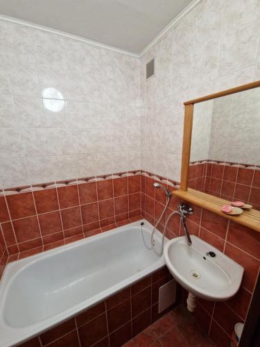 ein Badezimmer mit einer Badewanne und einem Waschbecken in der Unterkunft Sankt Martin Hostel in Martin