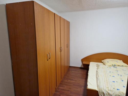 a bedroom with a bed and a wooden cabinet at Sankt Martin Hostel in Martin