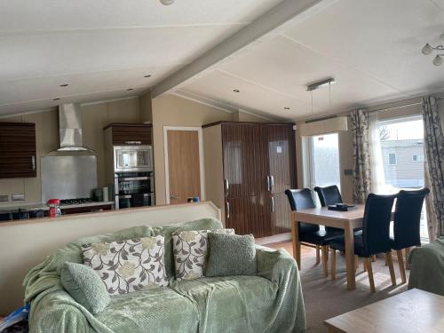 a living room with a couch and a table at 3 Bedroom Lodge - Willows 24, Trecco Bay in Newton