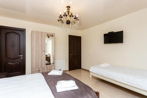 a bedroom with a large bed and a chandelier at Prime location Apartment with Three Bedroom in Tbilisi City