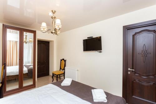 a bedroom with a bed and a tv on the wall at Prime location Apartment with Three Bedroom in Tbilisi City