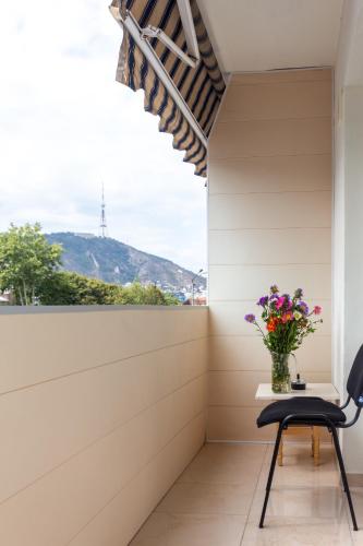 a room with a table and a chair and a vase of flowers at Prime location Apartment with Three Bedroom in Tbilisi City