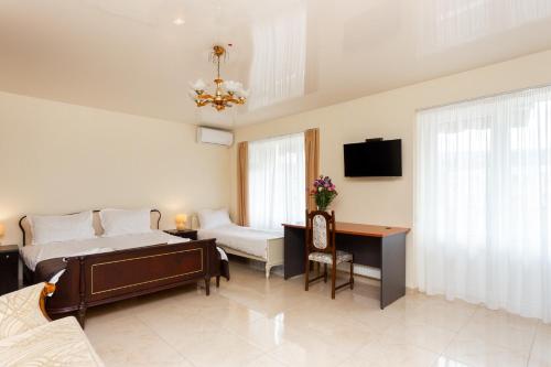 a bedroom with two beds and a desk and a tv at Prime location Apartment with Three Bedroom in Tbilisi City