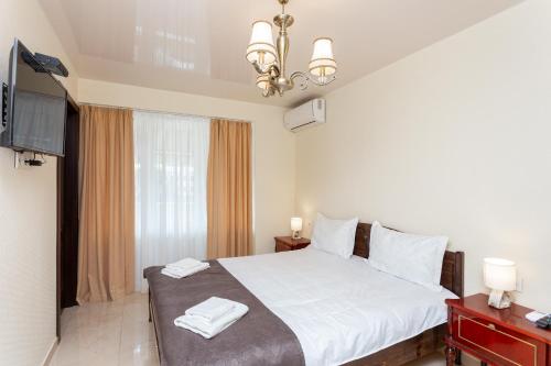 a bedroom with a white bed and a television at Prime location Apartment with Three Bedroom in Tbilisi City