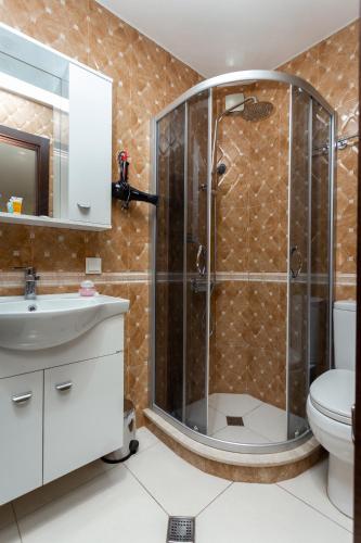 a bathroom with a shower with a sink and a toilet at Prime location Apartment with Three Bedroom in Tbilisi City
