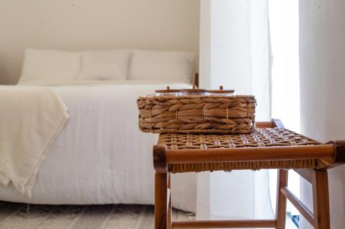 a bedroom with a bed with a basket on a stool at New Beachfront Penthouse Punta Popy in Las Terrenas