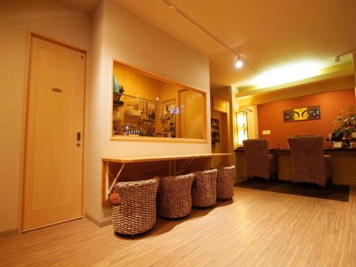 a living room with a row of chairs and a table at Guesthouse Nara Komachi in Nara