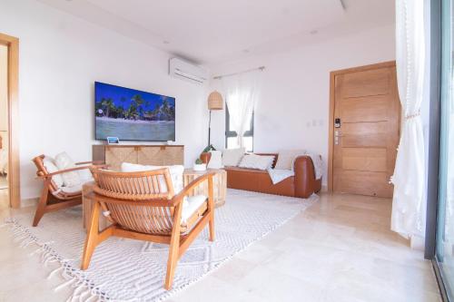a living room with a table and chairs and a couch at New Beachfront Penthouse Punta Popy in Las Terrenas