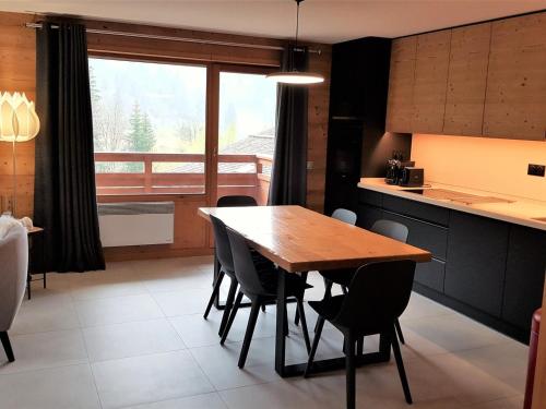 une cuisine et une salle à manger avec une table et des chaises en bois dans l'établissement Appartement 3 pièces avec balcon et garage proche des pistes - FR-1-459-142, à La Clusaz