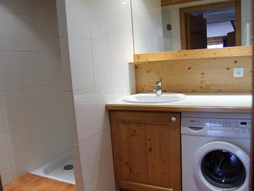 une salle de bain avec une machine à laver et un lavabo dans l'établissement Appartement 3 pièces avec balcon et garage proche des pistes - FR-1-459-142, à La Clusaz