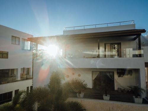a building with the sun shining on the side of it at New Beachfront Penthouse Punta Popy in Las Terrenas