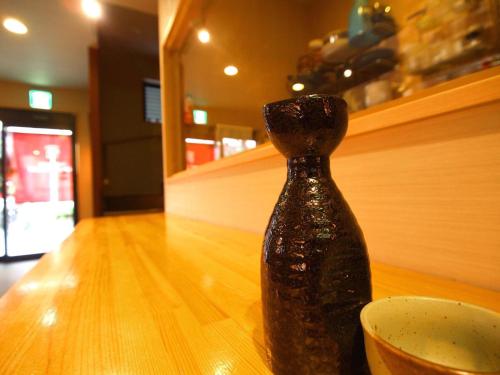 a bottle sitting on a table next to a bowl at Guesthouse Nara Komachi in Nara