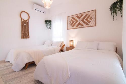 a white room with two beds and a mirror at New Beachfront Penthouse Punta Popy in Las Terrenas