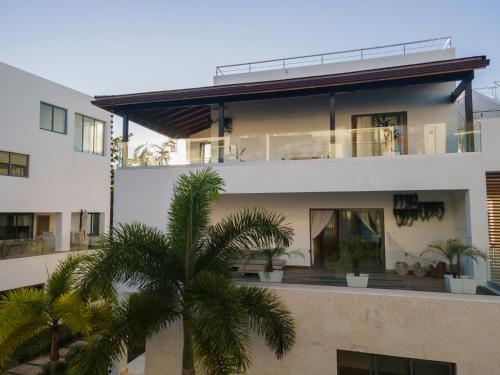 a building with palm trees in front of it at New Beachfront Penthouse Punta Popy in Las Terrenas