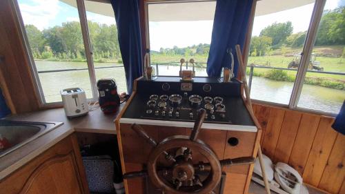 a stove in a kitchen with a view of a river at Péniche sur un lac in Campsegret